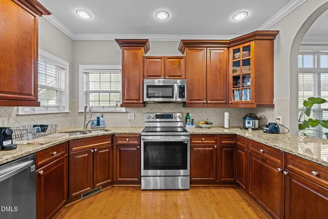 a kitchen with stainless steel appliances granite countertop a stove microwave and sink