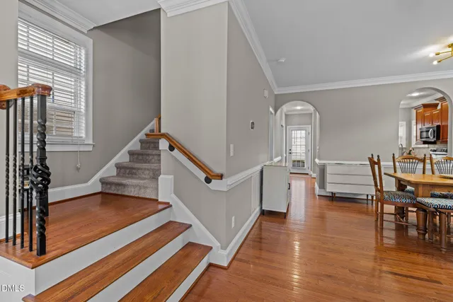 a dining room with a table and chairs with wooden floor