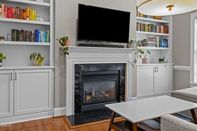 a living room with a wooden floor and a fireplace