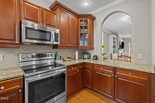 a kitchen with stainless steel appliances granite countertop a stove microwave and sink