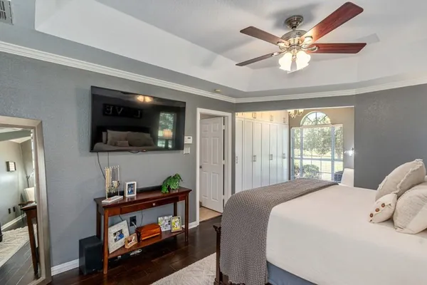 a bedroom with a large bed a flat tv screen and a dresser