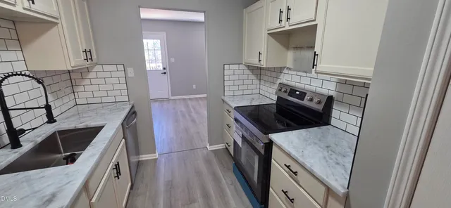 a kitchen with granite countertop a stove and a sink