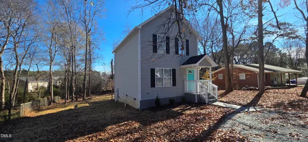 a view of a grey house with a yard