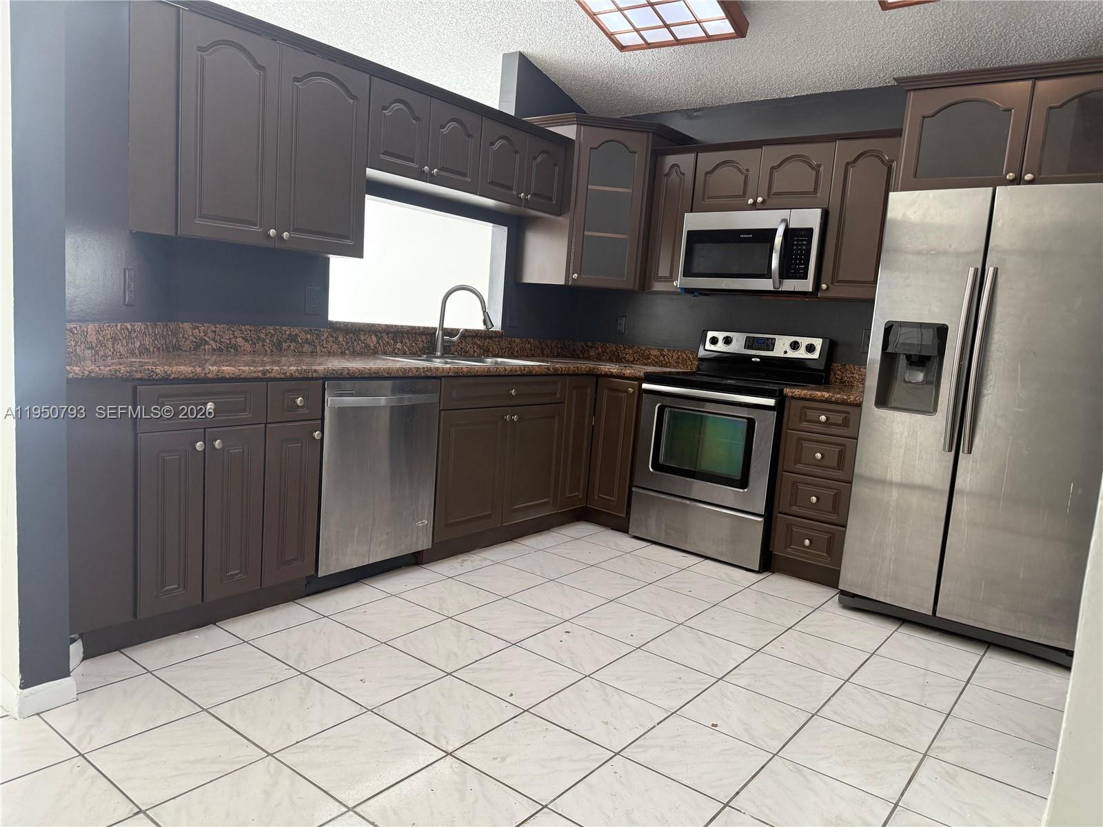 206 Southwest 159th Way Sunrise, FL 33326 - Photo 60 of 61 a kitchen with stainless steel appliances granite countertop a refrigerator and a sink