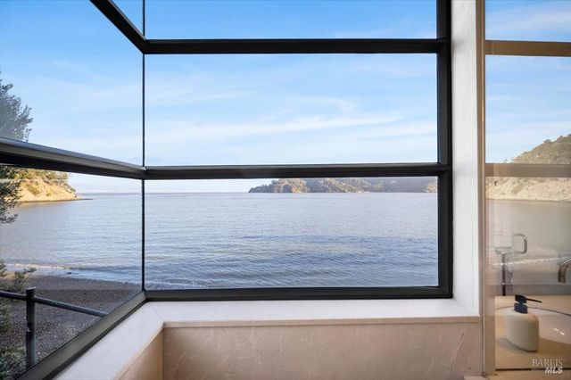 a kitchen with stainless steel appliances granite countertop a stove and a view of living room