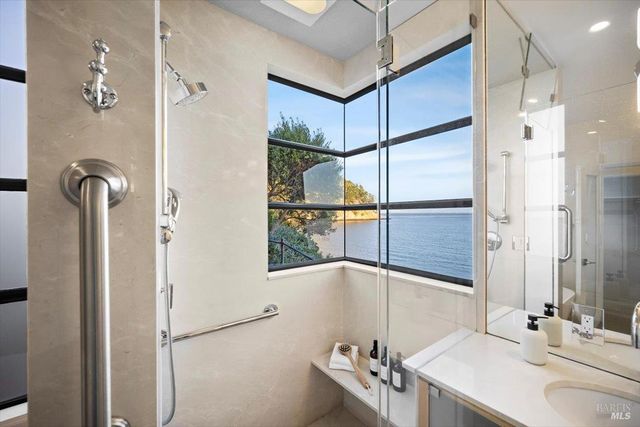 a bathroom with a white bath tub a mirror and a shower