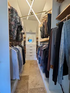 a view of walk in closet with clothes and shoes