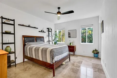 a bedroom with a balcony a bed and a window