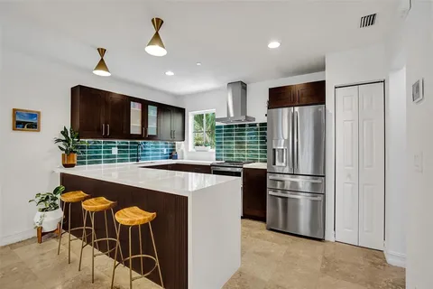 a kitchen with stainless steel appliances kitchen island a refrigerator sink and cabinets