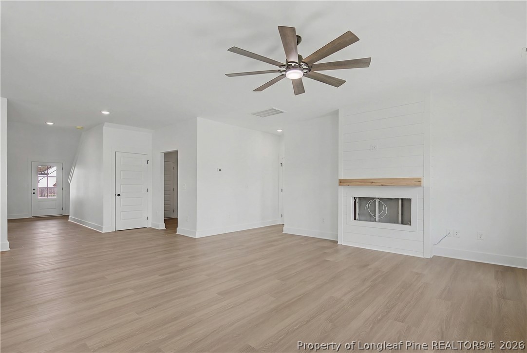 5076 Ross West Road Dunn, NC 28334 - Photo 4 of 8 a view of a big room with wooden floor and windows