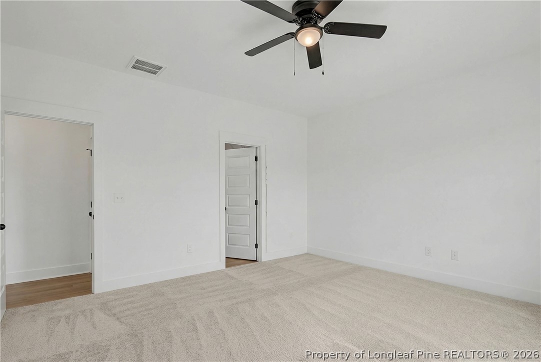 5076 Ross West Road Dunn, NC 28334 - Photo 6 of 8 an empty room with a ceiling fan and a window