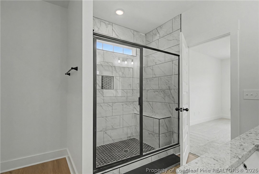 5076 Ross West Road Dunn, NC 28334 - Photo 7 of 8 a bathroom with a glass shower door