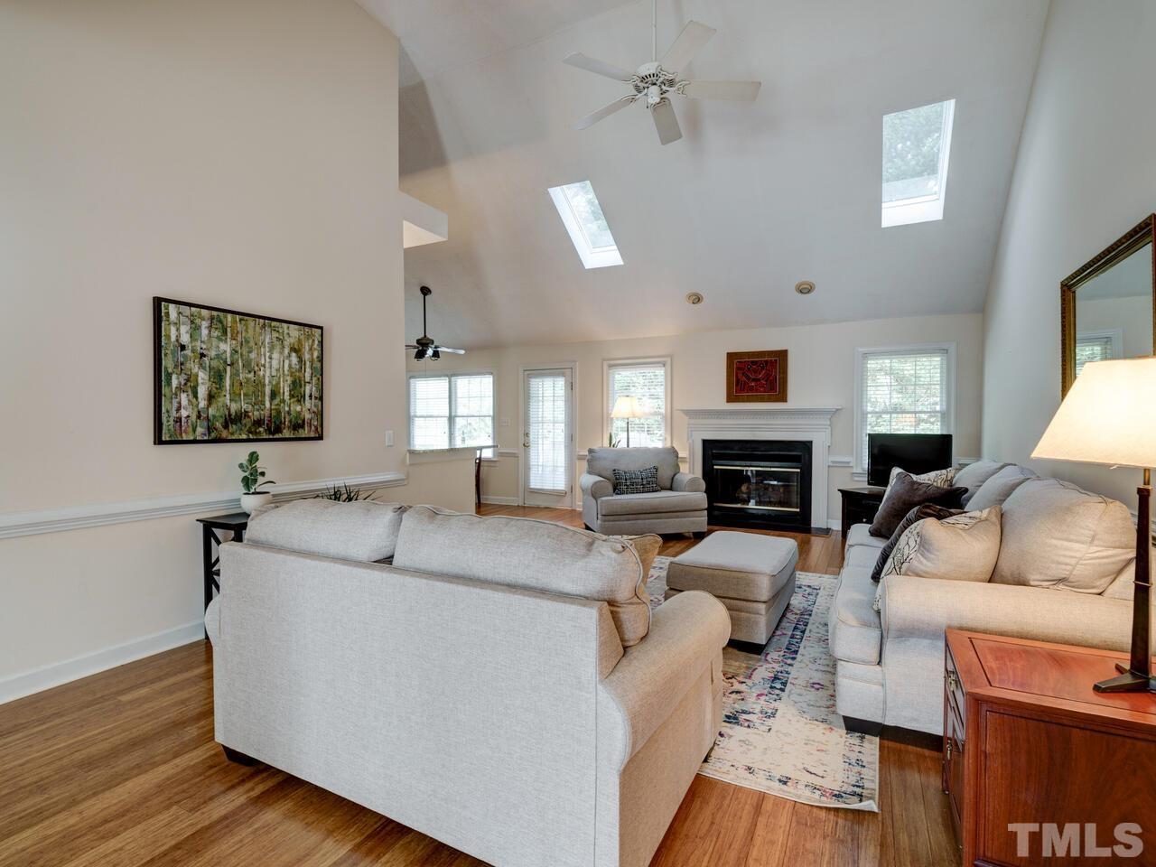 12108 Amoretto Way Raleigh, NC 27613 - Photo 17 of 40 a living room with furniture a fireplace and a flat screen tv