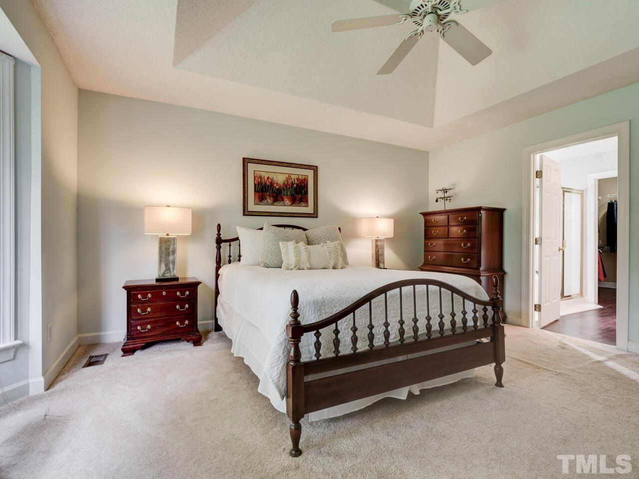 12108 Amoretto Way Raleigh, NC 27613 - Photo 24 of 40 a bedroom with a bed and a chandelier