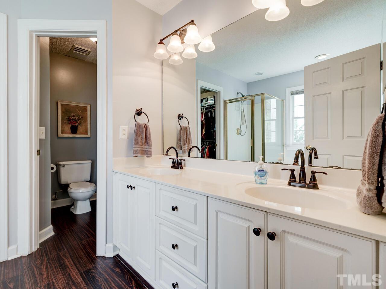 12108 Amoretto Way Raleigh, NC 27613 - Photo 28 of 40 a bathroom with a sink a toilet and a large mirror