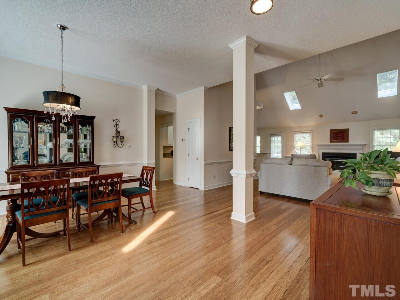 12108 Amoretto Way Raleigh, NC 27613 - Photo 3 of 40 a view of a dining room and livingroom with furniture wooden floor a chandelier