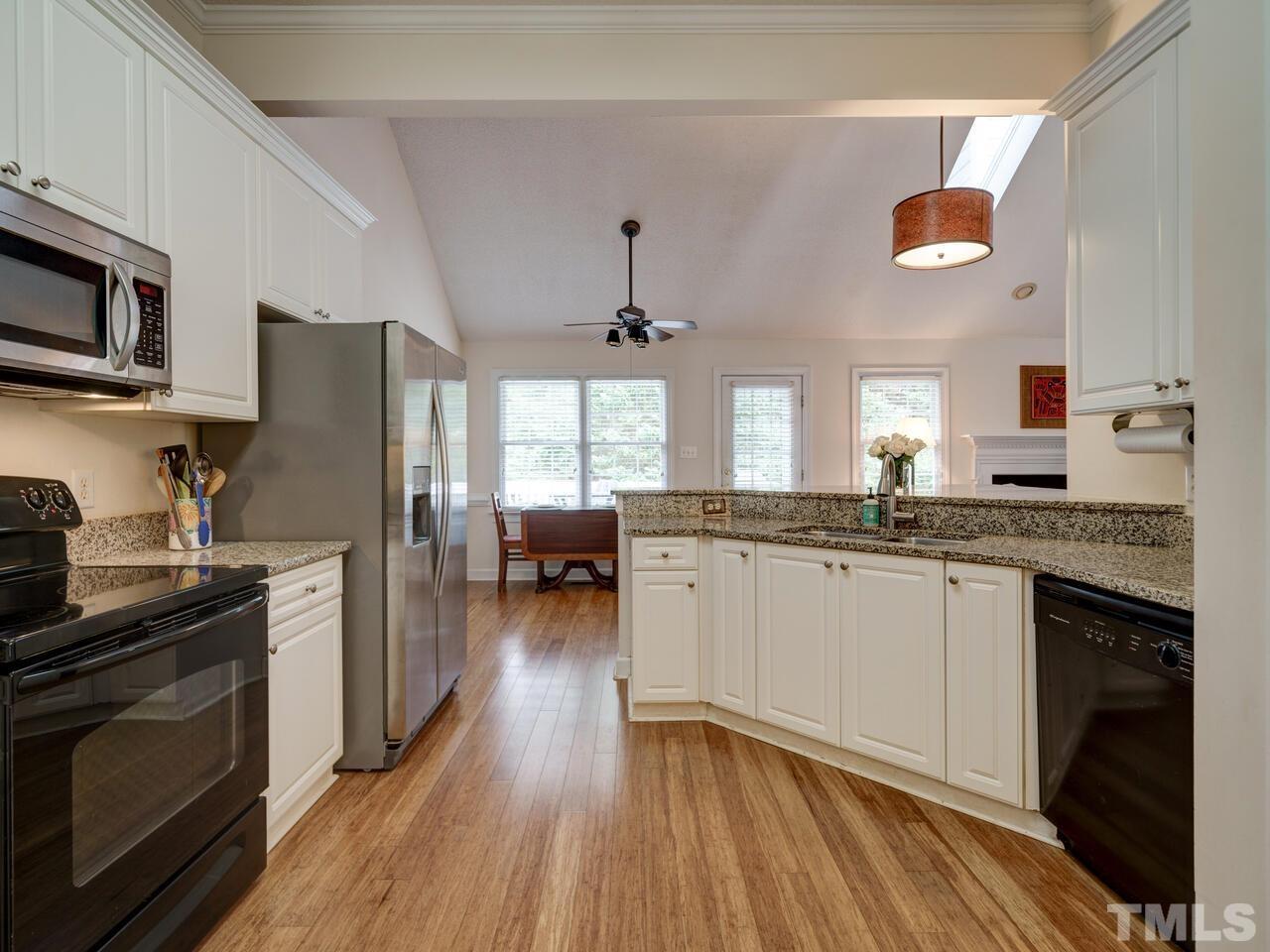 12108 Amoretto Way Raleigh, NC 27613 - Photo 6 of 40 a kitchen with granite countertop a refrigerator stove top oven and sink