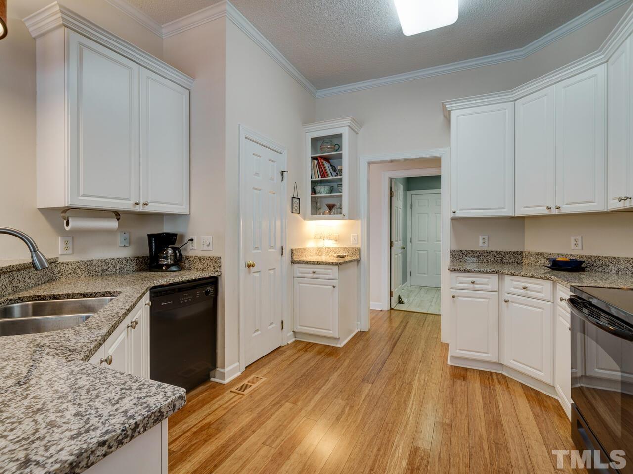 12108 Amoretto Way Raleigh, NC 27613 - Photo 8 of 40 a kitchen with granite countertop wooden floors and stainless steel appliances