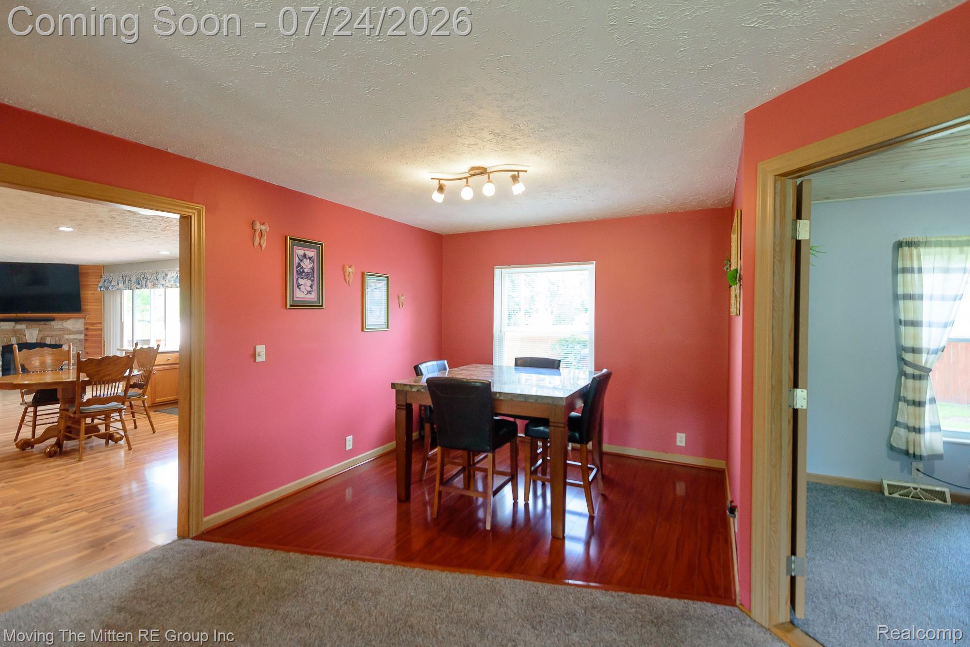 37460 Tyler Road Romulus, MI 48174 - Photo 16 of 52 Dining area featuring wood-finish flooring, a contemporary ceiling light fixture, a window providing natural illumination, and wood trim throughout