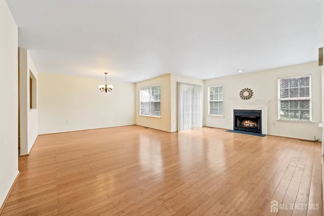 a view of empty room with wooden floor and fireplace