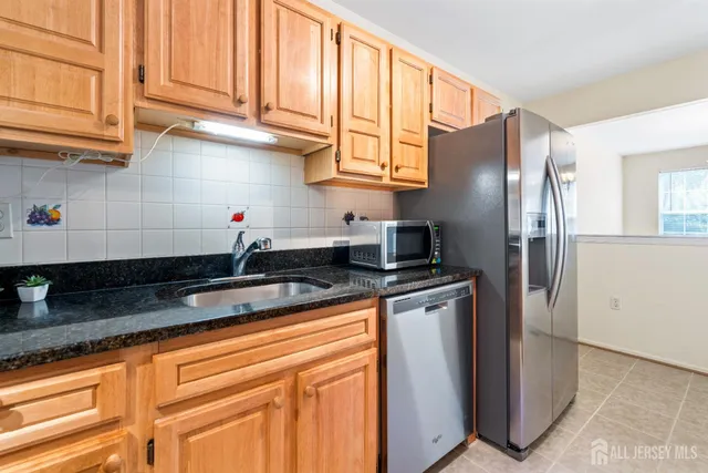 a kitchen with stainless steel appliances granite countertop a refrigerator sink and cabinets