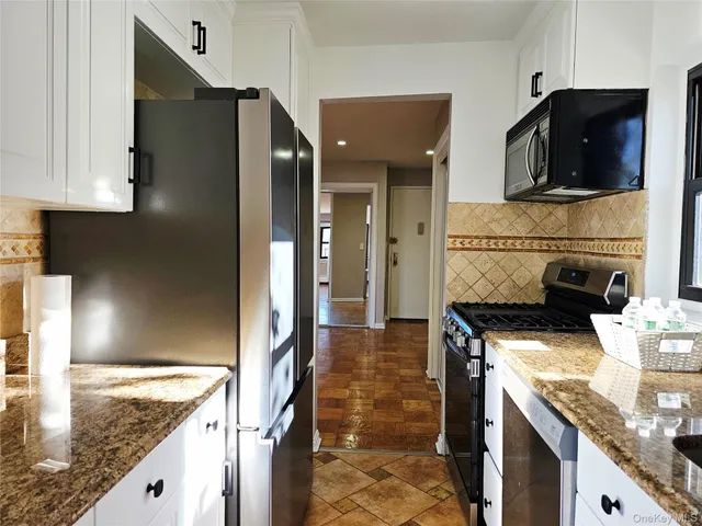 a kitchen with granite countertop a stove and a refrigerator