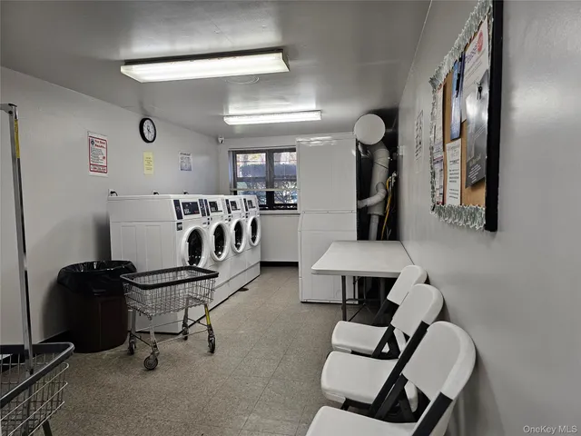 a view of a brick wall with a chair and table in the patio