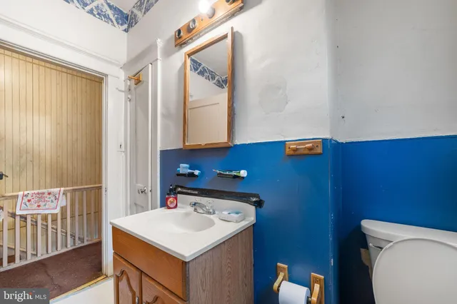 a bathroom with a sink a toilet and a mirror