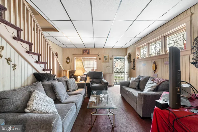 a living room with furniture a couch and a large window
