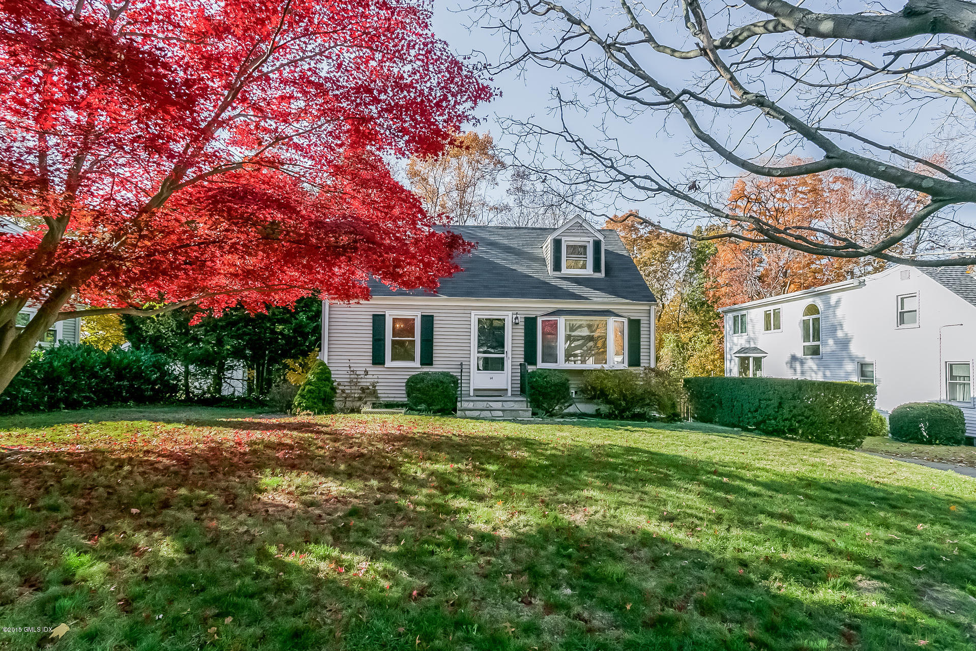 a front view of a house with a yard and trees