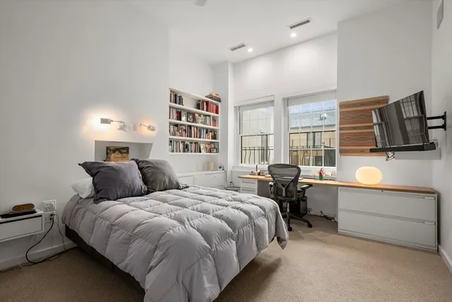 a bed room with a bed tv and a window