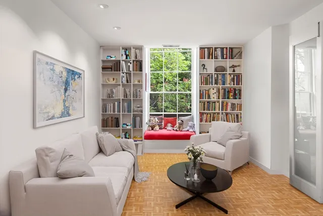 a living room with furniture and a book shelf