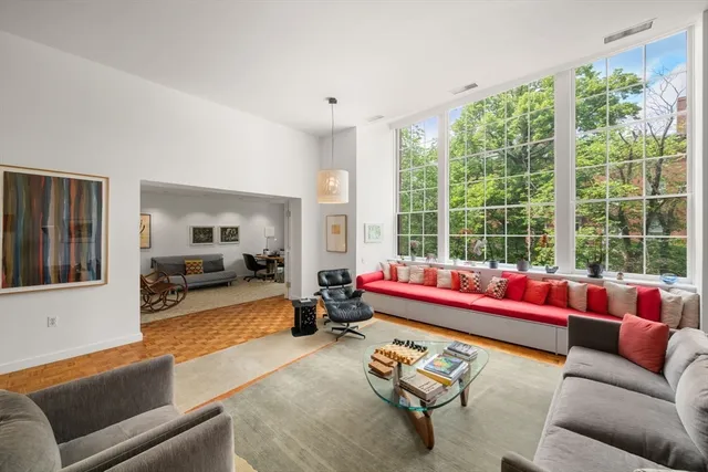 a living room with furniture and floor to ceiling windows