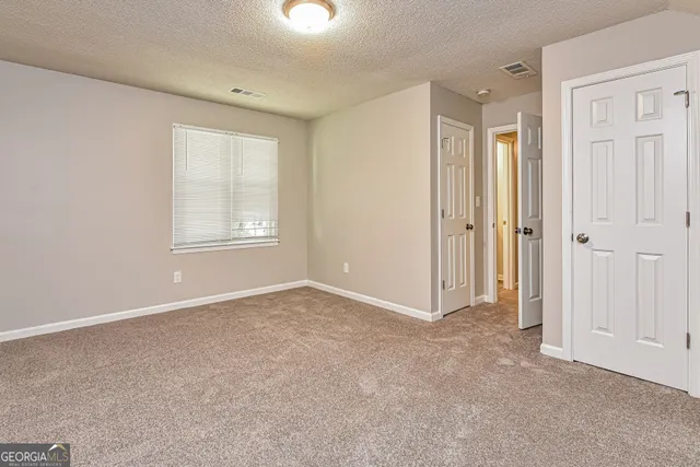 an empty room with windows and closet