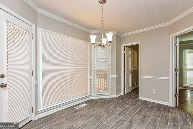 an empty room and wooden floor chandelier and windows