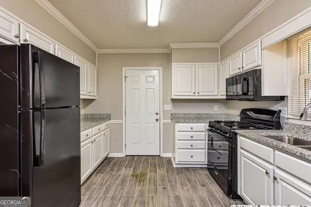 a kitchen with white cabinets stainless steel appliances and a window