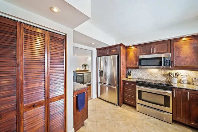 a kitchen with stainless steel appliances granite countertop a refrigerator and a stove