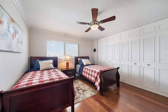 a bedroom with two beds and painting on the wall
