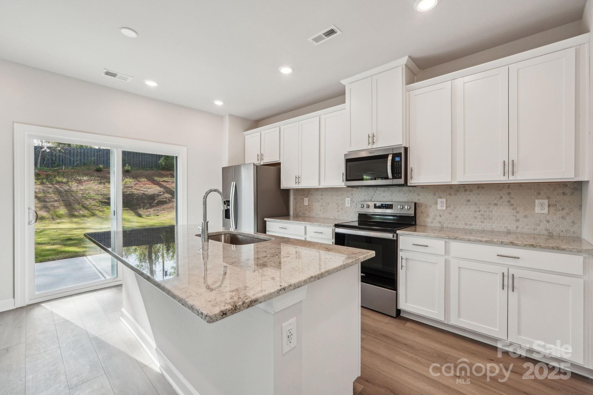 1516 31st Street Northeast Conover, NC 28613 - Photo 6 of 18 a kitchen with granite countertop a stove sink and microwave