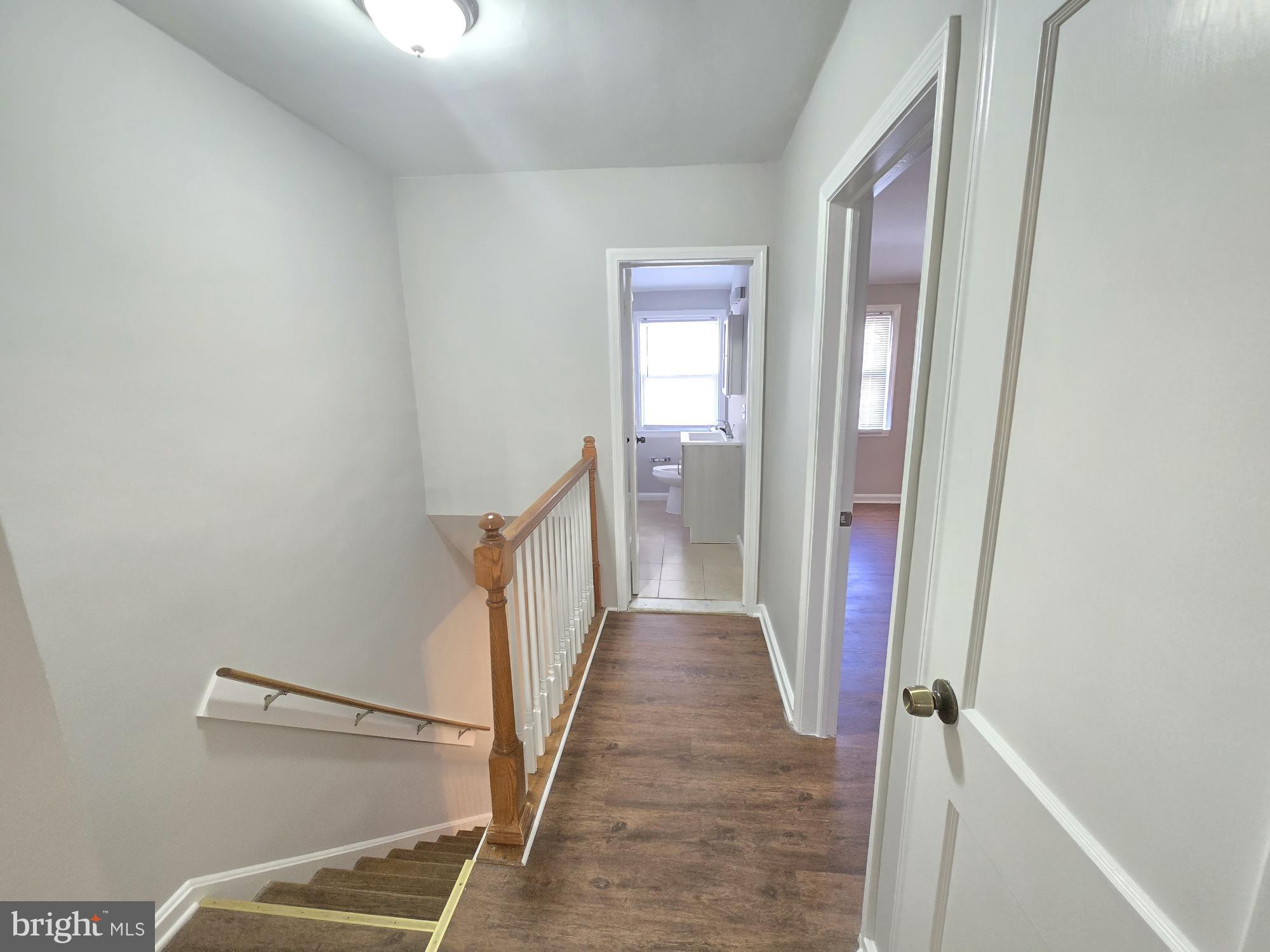 1225 Cochran Avenue Baltimore, MD 21239 - Photo 12 of 22 a view of a hallway with wooden floor and staircase