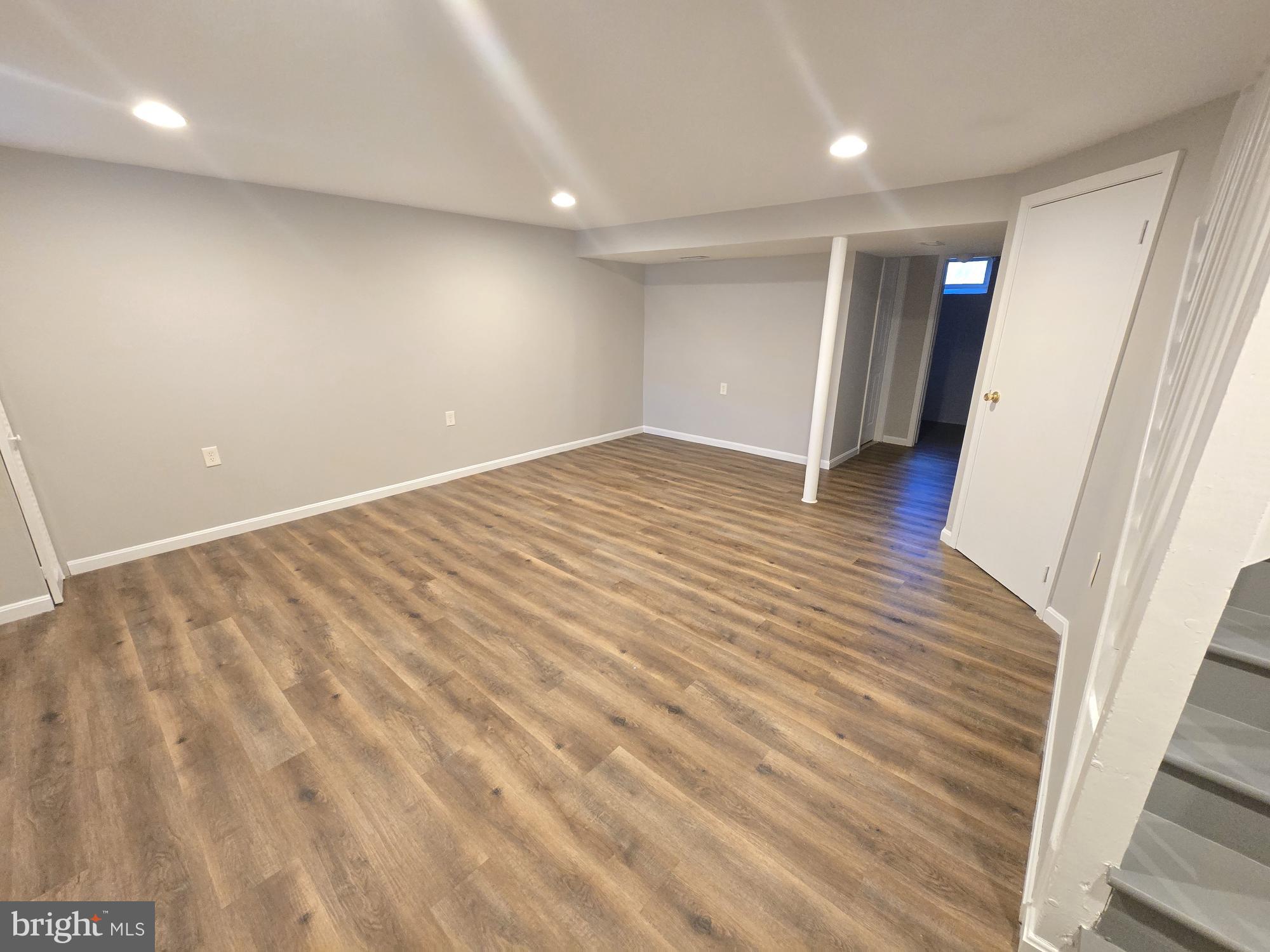 1225 Cochran Avenue Baltimore, MD 21239 - Photo 16 of 22 a view of an empty room with wooden floor and a window