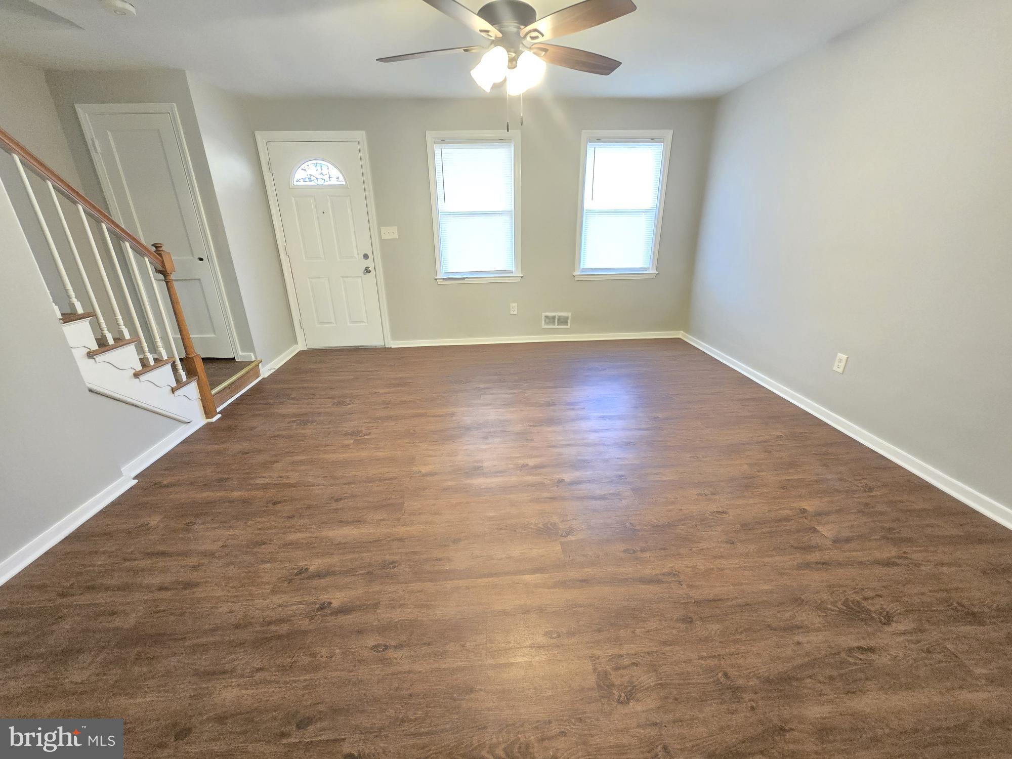 1225 Cochran Avenue Baltimore, MD 21239 - Photo 3 of 22 an empty room with wooden floor and windows