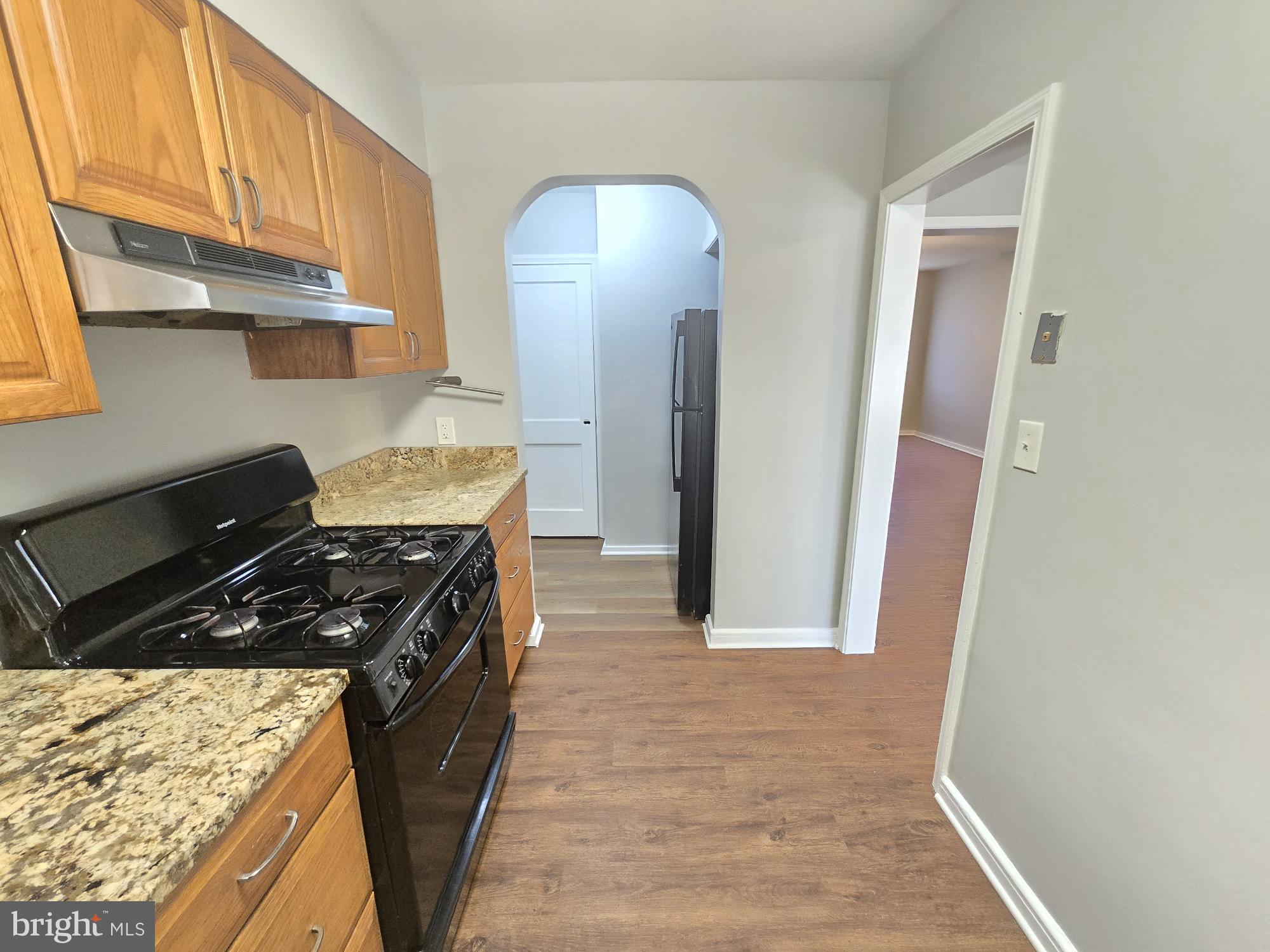1225 Cochran Avenue Baltimore, MD 21239 - Photo 7 of 22 a kitchen with granite countertop a stove and a refrigerator