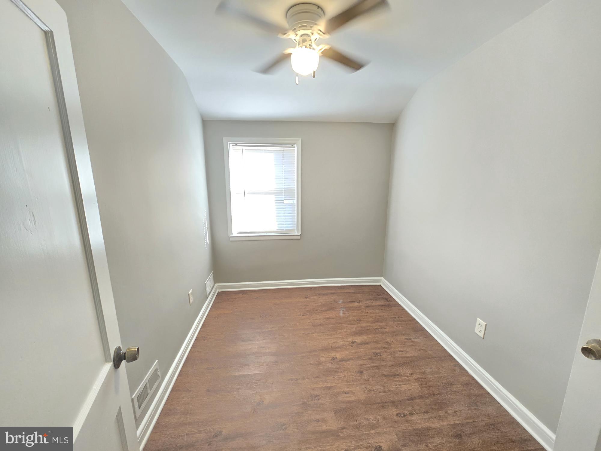 1225 Cochran Avenue Baltimore, MD 21239 - Photo 10 of 22 an empty room with windows and fan