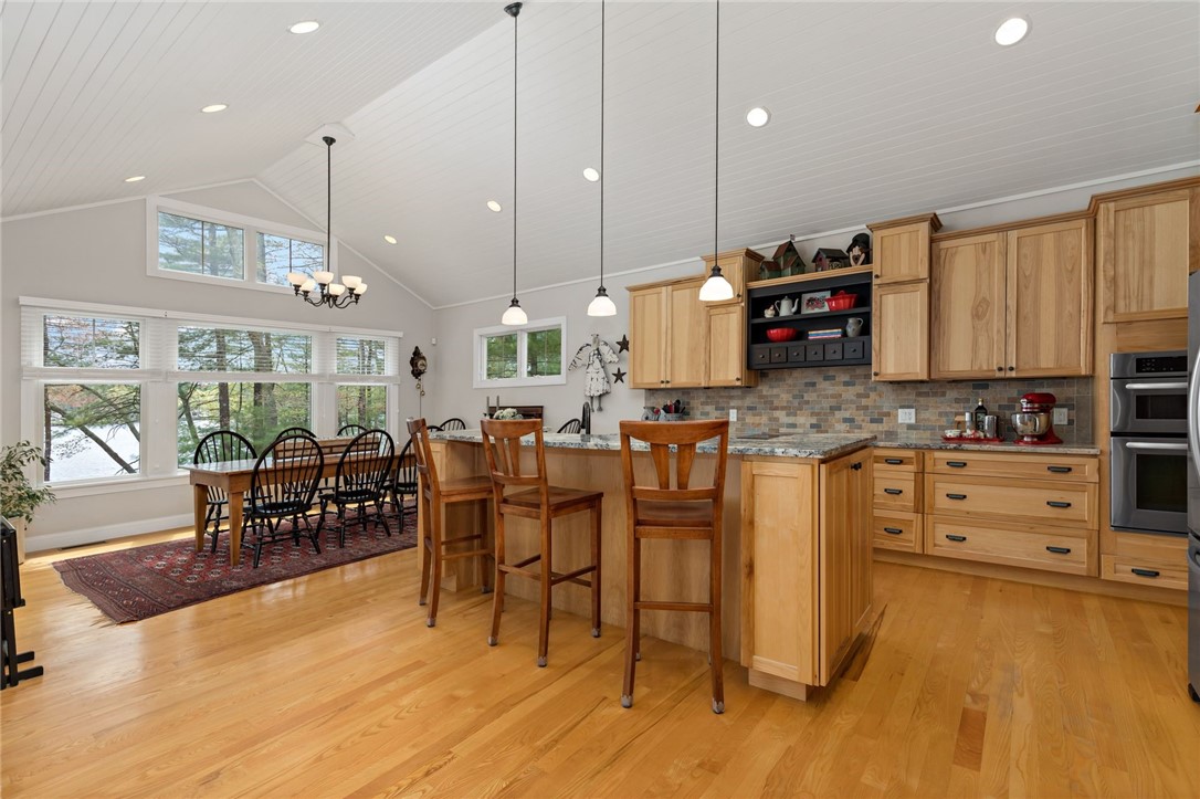 77 Raymonds Point Road Coventry, RI 02816 - Photo 23 of 50 Kitchen and dining room with shiplap cathedral ceiling, center island, hickory cabinets, Persa Blue Granite and stainless steel appliances.