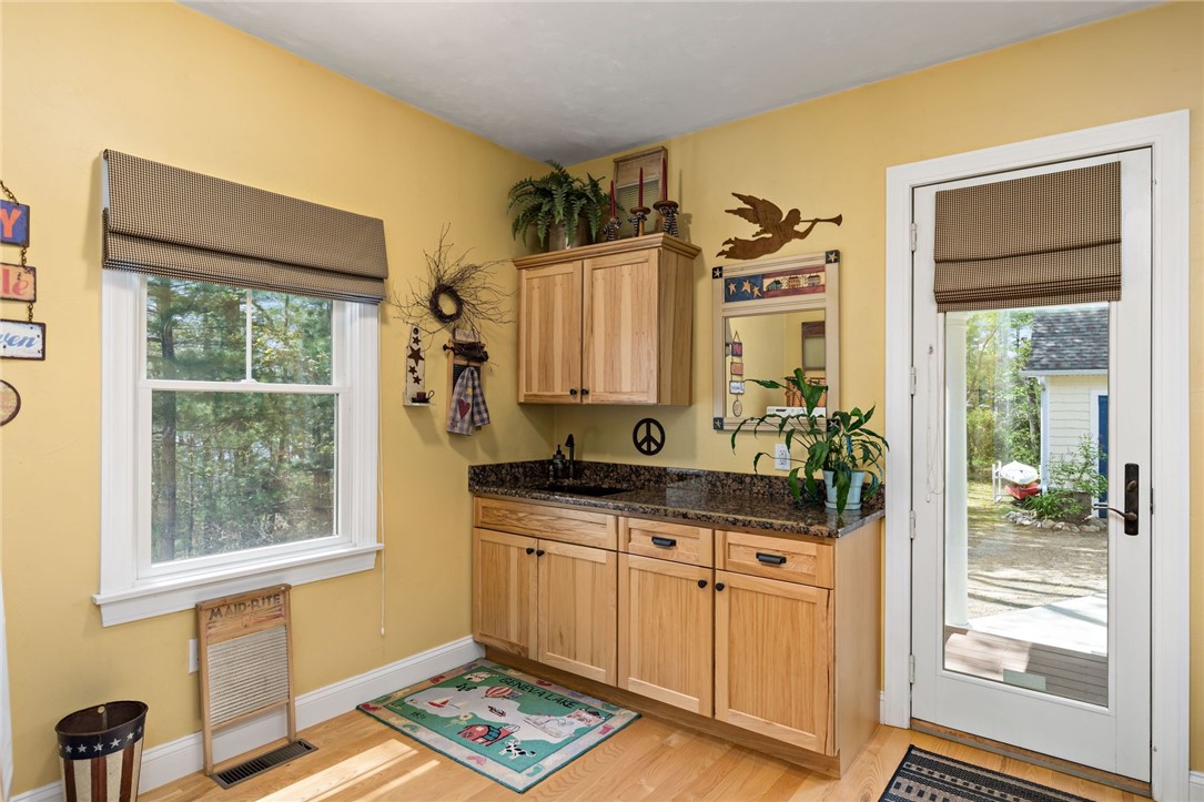 77 Raymonds Point Road Coventry, RI 02816 - Photo 30 of 50 Laundry room with hickory cabinets, granite and sink. Exit to side porch, courtyard and garage.