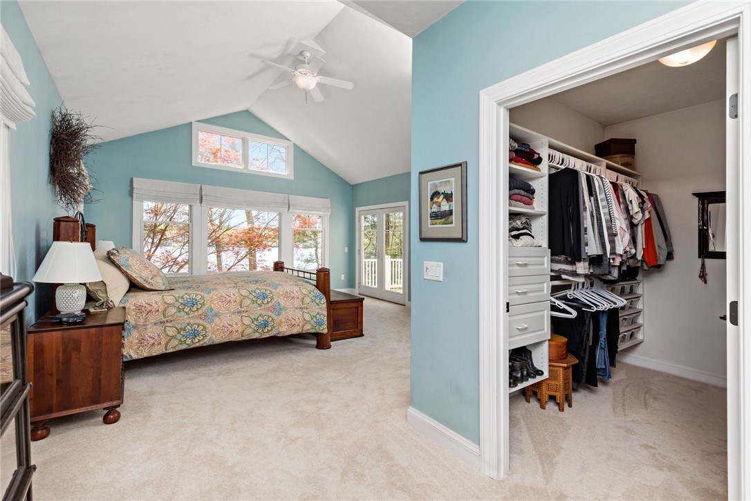 77 Raymonds Point Road Coventry, RI 02816 - Photo 32 of 50 Master bed with cathedral ceiling, view of the pond and the beautiful red maple that was preserved when the property was torn down and re-constructed, and French doors out to the deck. Owner's closet #1.