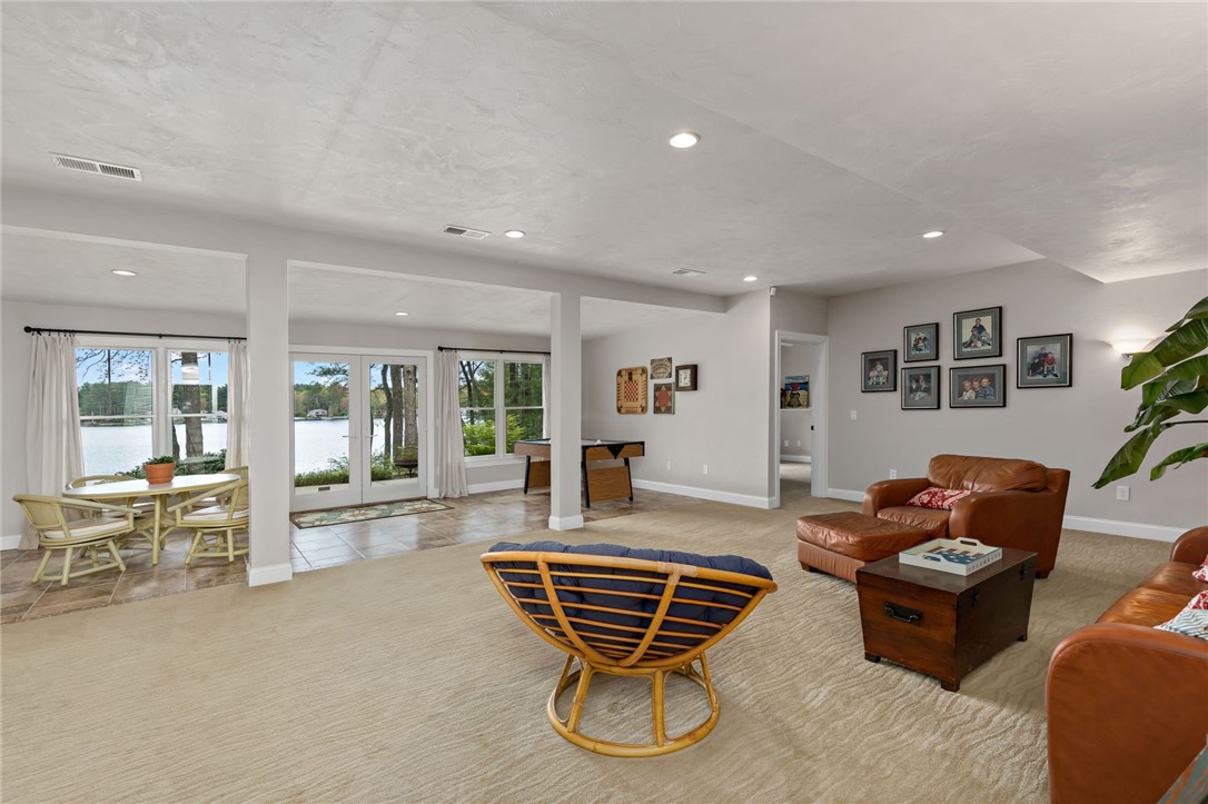 77 Raymonds Point Road Coventry, RI 02816 - Photo 44 of 50 Lower level family room with view of Johnson's Pond. Doorway on right leading into bedroom #3 and full-bath. Bedroom and bath #4 are accessed to the left of this space (not shown).