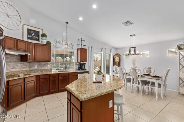 a kitchen with stainless steel appliances granite countertop a kitchen island a stove and a cabinets