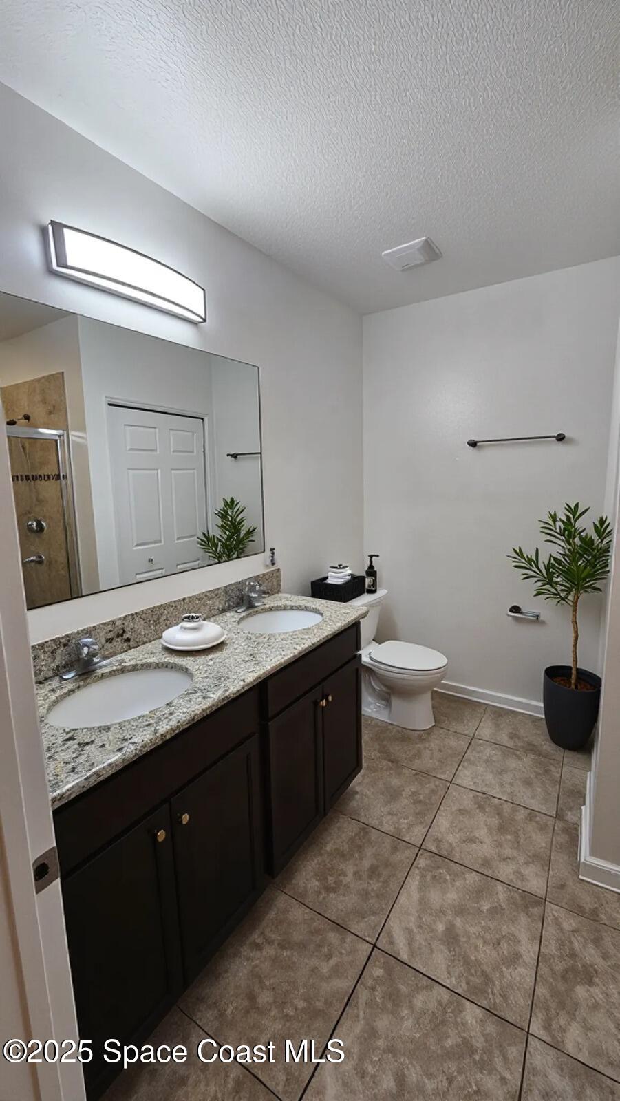 1877 Attilburgh Boulevard West Melbourne, FL 32904 - Photo 15 of 19 a spacious bathroom with a granite countertop sink a toilet and a mirror
